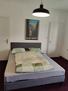 a bed in a bedroom with a poster on the wall at 1 Zimmer Studio mit Kitchenette in Bad Ragaz