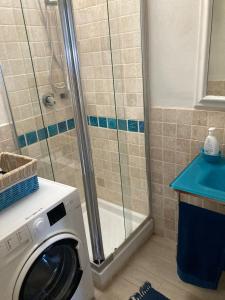 a washing machine in a bathroom with a shower at Appartamento vista mare Capo Falcone in Stintino