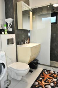 ein Badezimmer mit Toilette und Waschbecken in der Unterkunft Promenada Beach Residence in Mamaia Nord – Năvodari