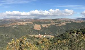 a view of a valley with a house in the mountains at Mosteirinho in Negreda