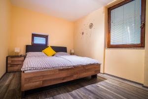 een slaapkamer met een houten bed met een geel kussen bij Apartment Veninsek in Luče