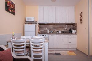 a kitchen with white cabinets and white stools at Studio 6,Smolyan lakes in Smolyan