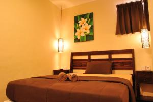 a bedroom with a bed with two towels on it at Bemo Corner Guest House in Kuta