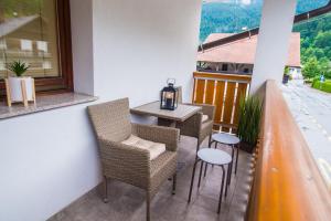 a balcony with chairs and a table with a candle on it at Apartment Veninsek in Luče