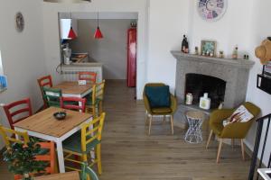 comedor con mesas y sillas y chimenea en La Petite Famille en Corchiano