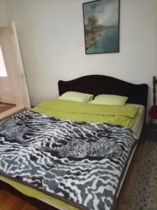 a bed with a black and white comforter in a bedroom at Apartman Biljana in Berovo
