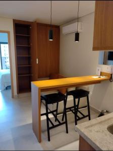 a kitchen with a wooden table and two stools at Salinas Premium Resort in Salinópolis