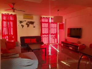 sala de estar con cortinas rojas y TV en Espacioso Duplex en Sevilla