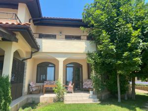 a house with a table and chairs in the yard at Black Sea Rama Golf and Villas, Bell Tower Villa in Balchik