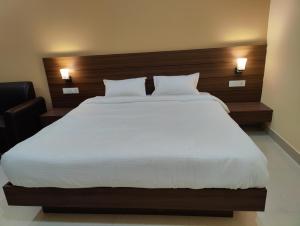 una camera da letto con un grande letto bianco con due cuscini di HR Garden(Hotel & Resort) a Deoghar