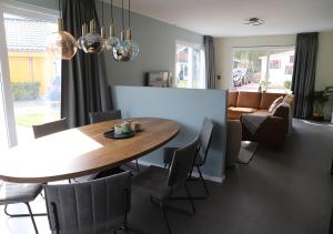 een eetkamer met een tafel en stoelen bij Chaletparc Krabbenkreek Zeeland - Chalet 232 in Sint Annaland