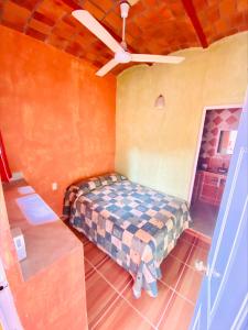 een slaapkamer met een bed en een plafondventilator bij Bungalows El Rincon de La Riviera in Rincon de Guayabitos