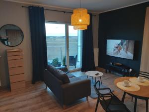 ein Wohnzimmer mit einem Sofa und einem Tisch in der Unterkunft Aparthotel - Buk in Buk