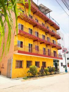 un bâtiment jaune avec des balcons sur son côté dans l'établissement Bungalows El Rincon de La Riviera, à Rincon de Guayabitos