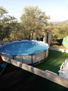 een zwembad met 2 stoelen en een parasol bij Casa dos Copins in Lamego