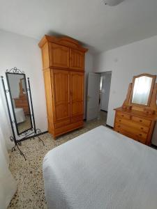 Schlafzimmer mit einem Bett, einer Kommode und einem Spiegel in der Unterkunft piso villavarela in Tarifa