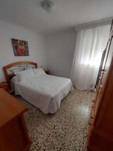 ein Schlafzimmer mit einem weißen Bett und einem Fenster in der Unterkunft piso villavarela in Tarifa