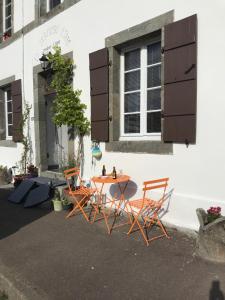 duas cadeiras e uma mesa em frente a um edifício em La Dernière Étape em Port-Launay