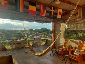 a patio with chairs and flags and a hammock at Amazon House Hostel in Iquitos