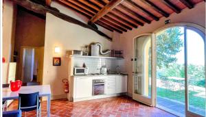 a kitchen with a table and a stove and a window at Incantevole borgo con piscine in Colleoli