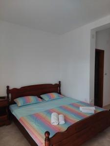 a bed with two towels and two slippers on it at Apartments Ivana in Ulcinj