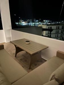 a wooden table sitting on top of a balcony at night at Aegean Breeze Kythnos Greek small apartment in Mérikhas