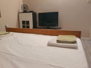 a bedroom with a bed with a monitor and a towel at apartman Luka in Sinj