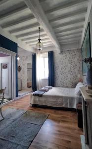 Schlafzimmer mit einem großen Bett und blauen Vorhängen in der Unterkunft Le Stanze di Matilde in Crevalcore