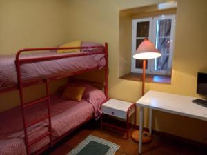 Pokój z 2 łóżkami piętrowymi i biurkiem z komputerem w obiekcie Casa Anita - Ribeira Sacra w mieście Os Peares