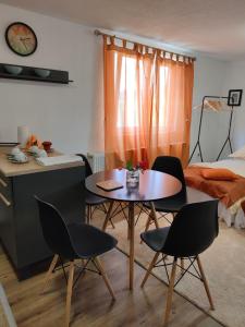 a room with a table and chairs and a bed at Dream Home Studio Apartments in Tuzla