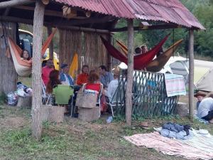 eine Gruppe von Personen, die in Hängematten in einem Zelt sitzen in der Unterkunft Camp Panorama in Guča