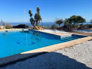 a swimming pool with the ocean in the background at VILLA CANTARES in Málaga