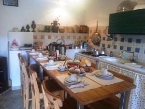 uma cozinha com uma mesa de madeira com pratos em La Suma Sumalia em Noto