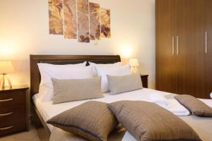 1 dormitorio con 1 cama con sábanas y almohadas blancas en IFESTOS APARTMENTS, en Ierissos