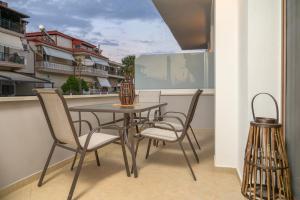 a dining room table and chairs on a balcony at IFESTOS APARTMENTS in Ierissos