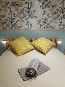 Una cama con dos almohadas y una toalla. en Maisonnette en Luberon, en Cadenet