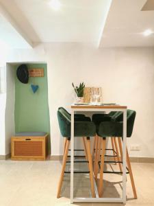 una mesa y 4 sillas verdes en una habitación en Maisonnette en Luberon, en Cadenet