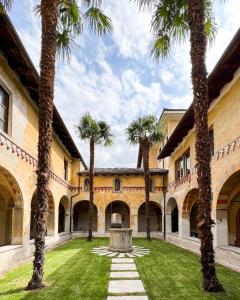 a courtyard with palm trees and a fountain at Convento Boutique Hotel in Susa