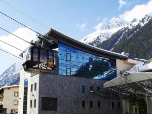 a ski lift in front of a building with mountains at Hotel Garni Angelika in Ischgl