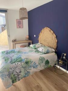 een slaapkamer met een bed met een blauwe muur bij T3 refait à neuf in Fleurance