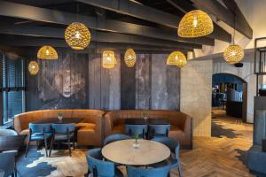 un restaurante con mesas, sillas y luces en Paping Hotel & Spa - Rest Vonck by Flow, en Ommen