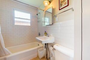 a white bathroom with a sink and a tub and a mirror at Notch Lodge in Franconia +63 photos