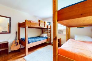 a bedroom with two bunk beds and a guitar at Notch Lodge in Franconia