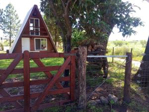 ein kleines Haus mit einem Tor und einem Zaun in der Unterkunft Paraje del Molino Casa Alpina in San José + 7 Fotos