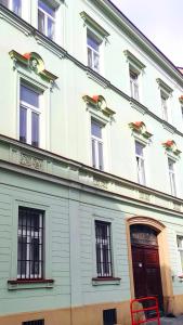 un edificio blanco con un banco rojo delante de él en Apartment Green House - Old Town, en Bratislava