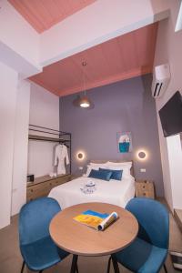 a bedroom with a bed and a table and chairs at Ialemos Group in Symi