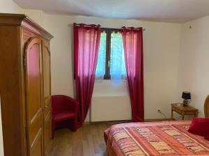 ein Schlafzimmer mit einem Bett, einem roten Stuhl und einem Fenster in der Unterkunft Appartement 10 min Stade de France coupe du monde de Rugby in Deuil-la-Barre