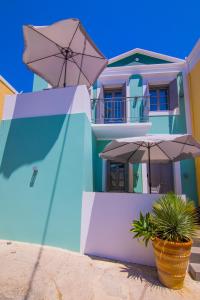 a blue and white house with an umbrella and a plant at Ialemos Group in Symi