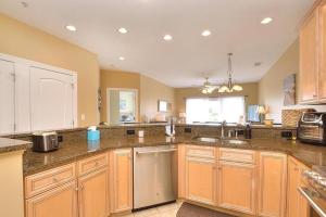 eine große Küche mit Holzschränken und einem Waschbecken in der Unterkunft Rock N Reel in Oak Island