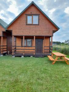 a log cabin with a picnic table in front of it at Malwa Domki Letniskowe in Rusinowo